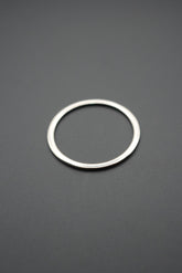 Anillo metálico redondo color plata sobre fondo gris