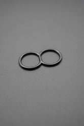 Anilla doble negra de metal sobre fondo gris