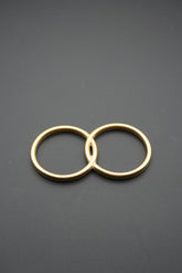 anillos entrecruzados dorados sobre fondo negro mate