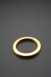 Arandela metálica dorada vista superior sobre fondo oscuro