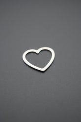 Colgante en forma de corazón abierto fabricado en plata sobre fondo gris