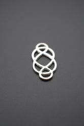 conector metálico de diseño geométrico sobre fondo gris