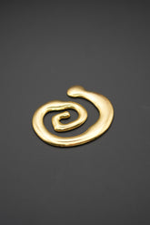 Broche dorado en forma de espiral sobre fondo gris oscuro
