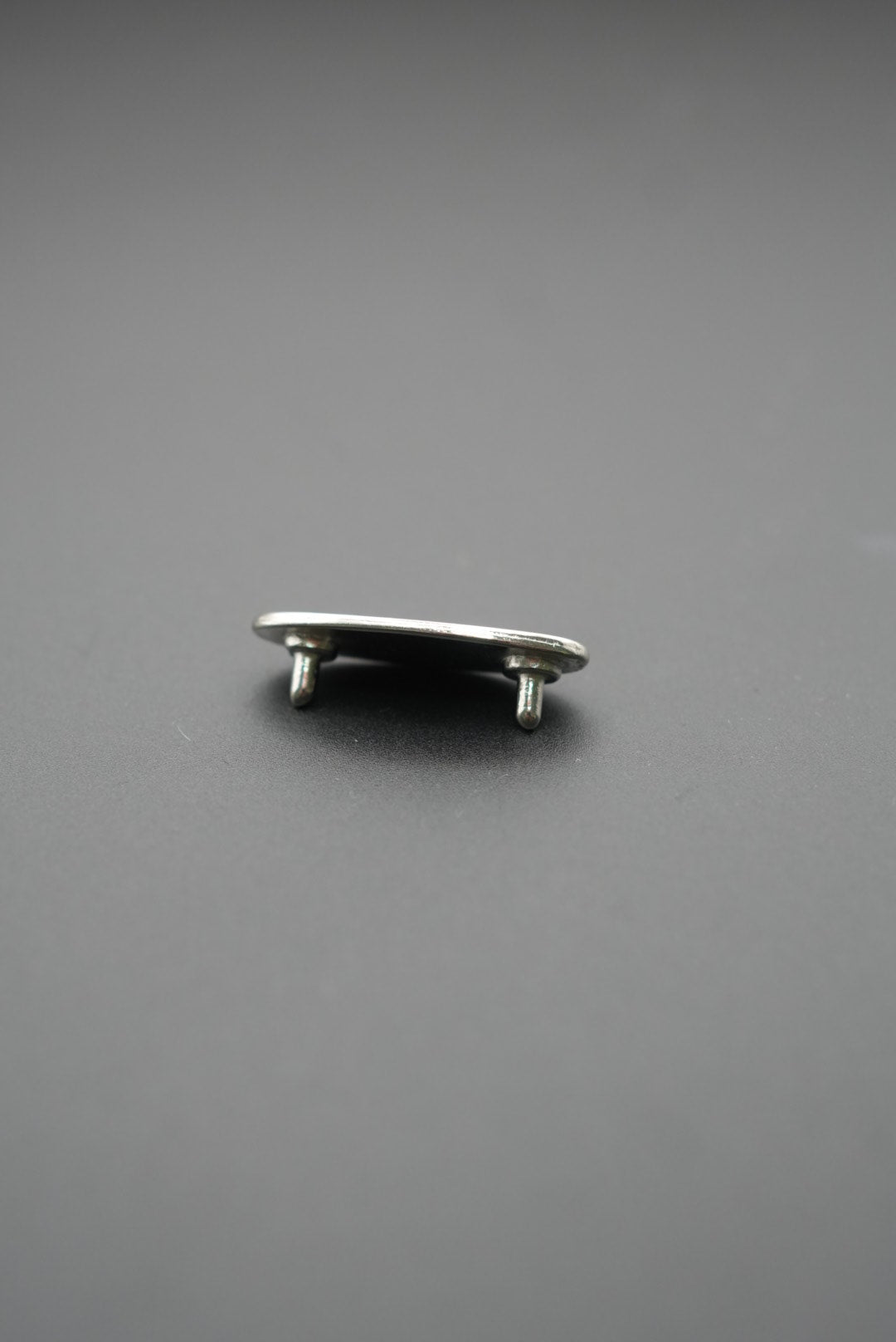 Vista lateral del remache metálico Tukson mostrando doble pin de fijación