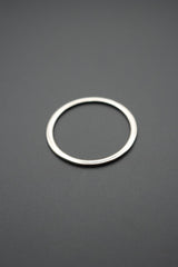 Anillo metálico redondo color plata sobre fondo gris