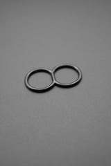 Anilla doble negra de metal sobre fondo gris