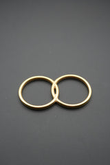 anillos entrecruzados dorados sobre fondo negro mate