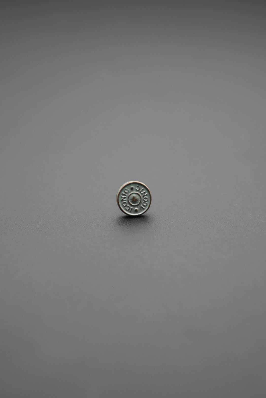 Botón metálico redondo con inscripción Conic en color plata envejecida