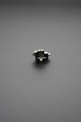 Pin metálico vista frontal sobre fondo gris