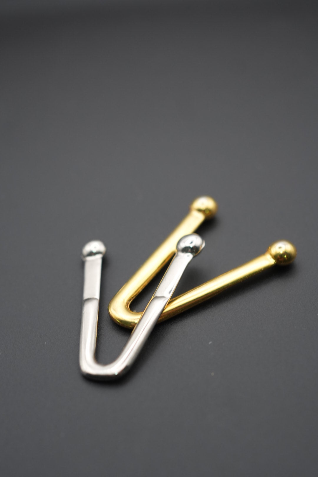 Juego de puntas metálicas en dorado y plateado sobre fondo gris oscuro