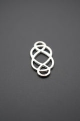 conector metálico de diseño geométrico sobre fondo gris