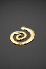 Broche dorado en forma de espiral sobre fondo gris oscuro