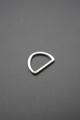 Vista cercana de arco metálico tipo D color plateado mostrando su forma y acabado