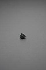 Botón de golpe en forma de escudo visto de lado con fondo gris