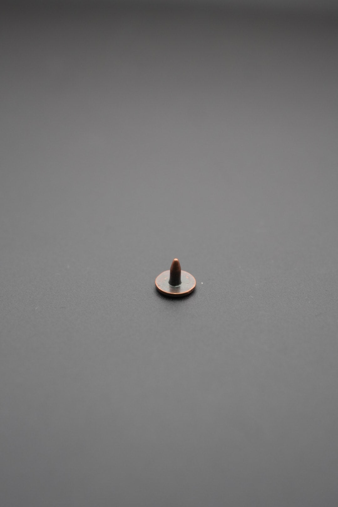 Vista trasera del remache metálico mostrando la punta para fijación