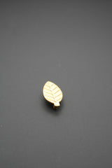 Vista frontal de tirador dorado en forma de hoja con relieve