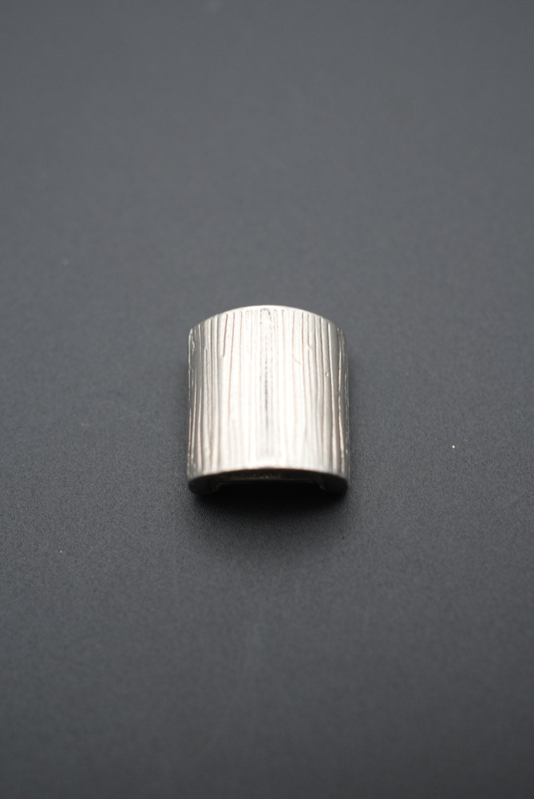 Vista frontal de protector de dedo metálico con acabado brillante y textura