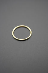 Anillo metálico redondo color dorado sobre fondo gris