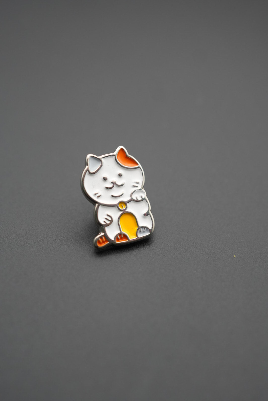 Vista frontal de pin personalizado gato Maneki-neko con acabado esmaltado brillante