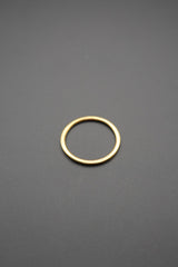 Vista superior de anillo dorado minimalista en superficie gris