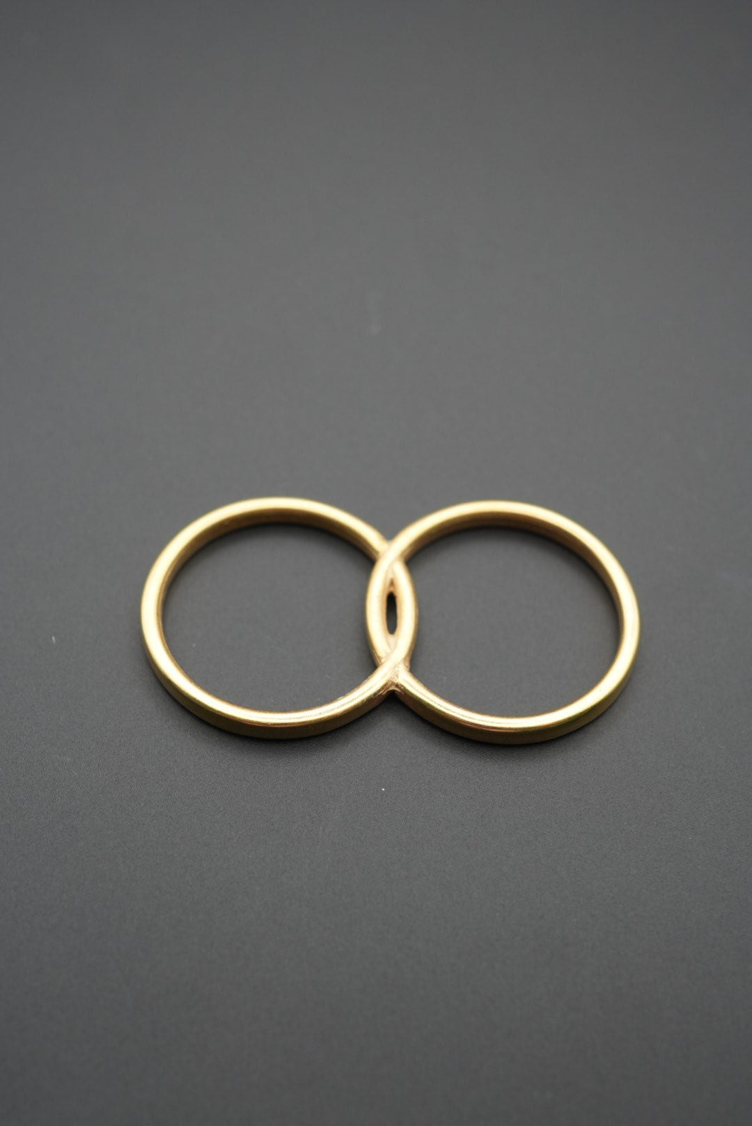 vista cercana de anillos dorados unidos entre sí sobre fondo oscuro