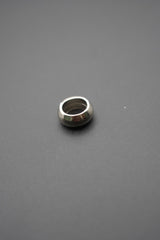 Arandela cónica de acero inoxidable vista lateral sobre fondo gris