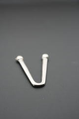 Gancho de metal en V con reflejos de luz en superficie pulida