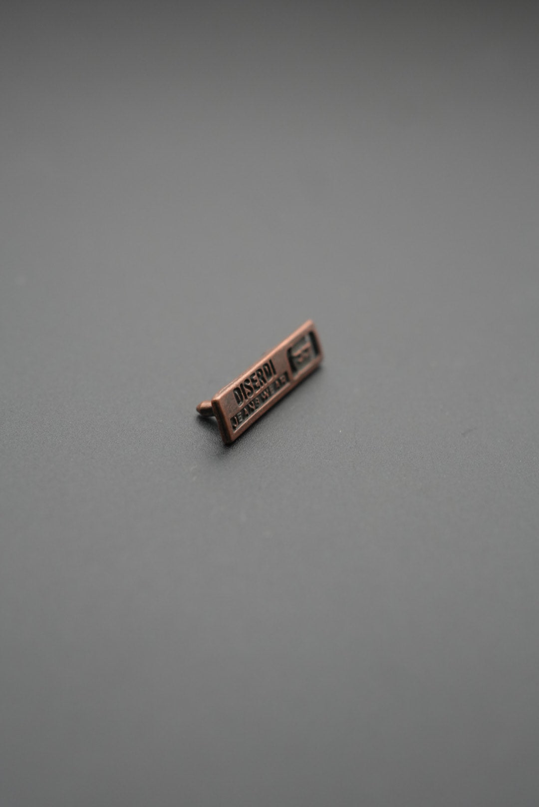 remache metálico vista lateral con texto Disenri Jeanswear