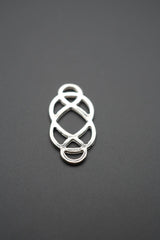 close-up del conector metálico decorativo con diseño entrelazado sobre fondo gris