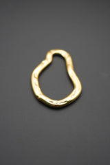 Primer plano de pulsera dorada con acabado brillante y contornos ondulados