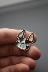 Primer plano del pin personalizado de bulldog francés en mano, resaltando calidad y diseño