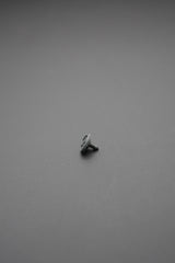 Vista lateral del botón de golpe metálico sobre fondo gris