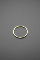 Anillo metálico redondo color dorado con acabado pulido sobre fondo gris