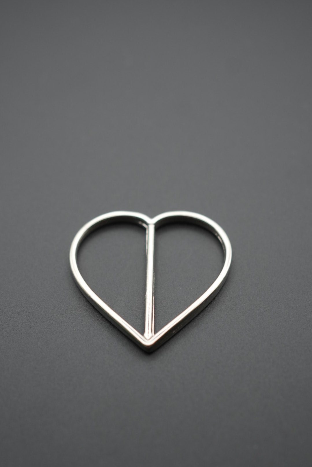 Hebilla metálica con barra central cerrado en forma de corazón