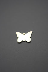 Vista reversa del dije mariposa metálico dorado mostrando superficie lisa