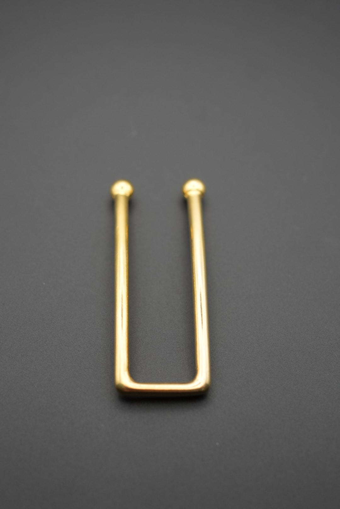 Primer plano del pasador metálico dorado con extremos redondeados