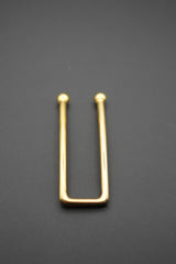 Primer plano del pasador metálico dorado con extremos redondeados