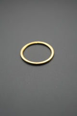 Anillo de diseño sencillo y pulido color dorado sobre fondo gris