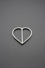 Detalle de hebilla metálica brillante con diseño en corazón