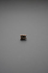 Tachuela metálica triangular con grabado de árboles en color bronce