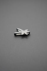 Lado izquierdo del pin metálico con diseño de libélula en fondo gris