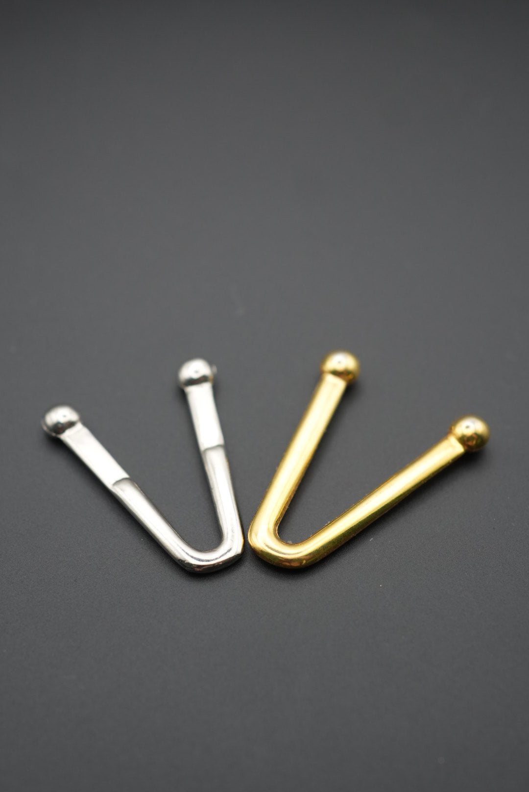 Detalle de puntas metálicas dorada y plateada en fondo gris