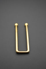 Vista lateral del pasador dorado mostrando su forma rectangular