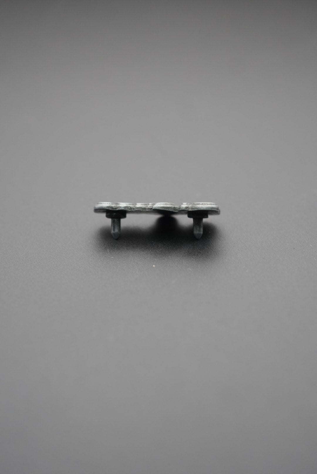 Vista en ángulo del remache metálico con diseño 'Signos'