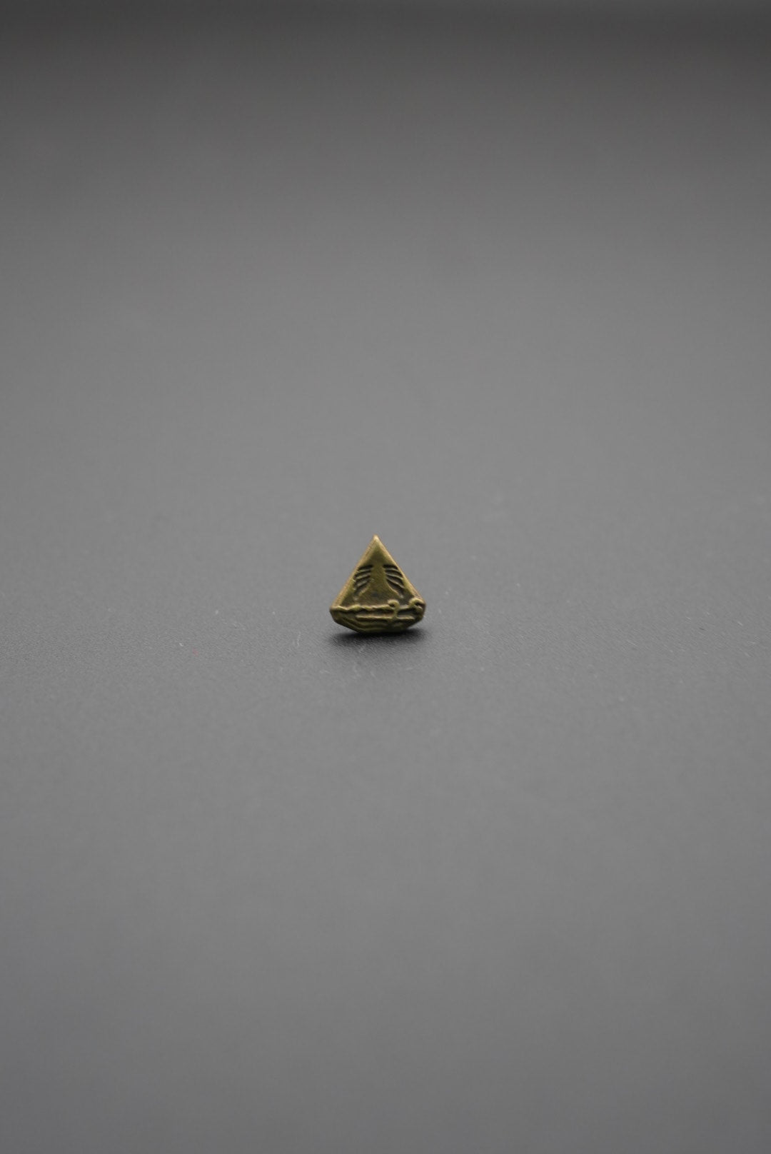 Vista lateral de tachuela metálica triangular mostrando el tornillo