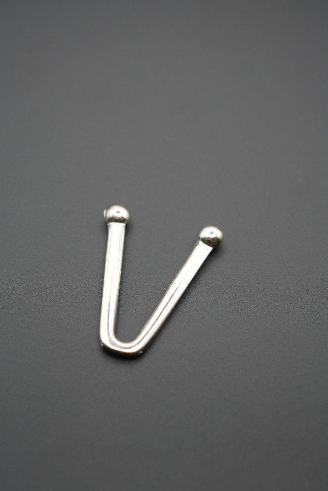 Primer plano del gancho metálico en forma de V con acabado brillante