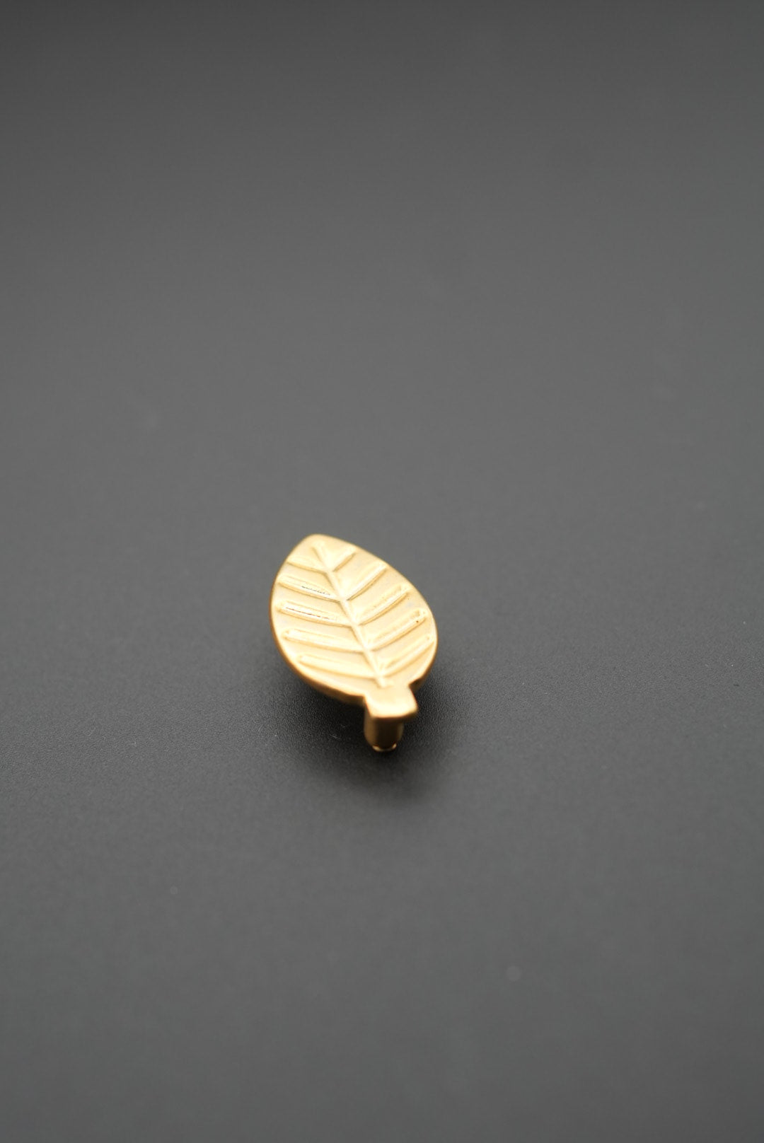 Tirador de mueble con diseño hoja en acabado dorado