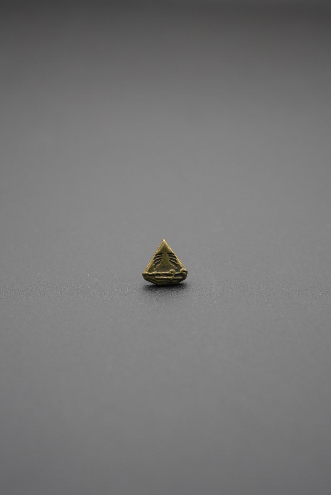 Vista de tachuela metálica triangular desde atrás con tornillo negro